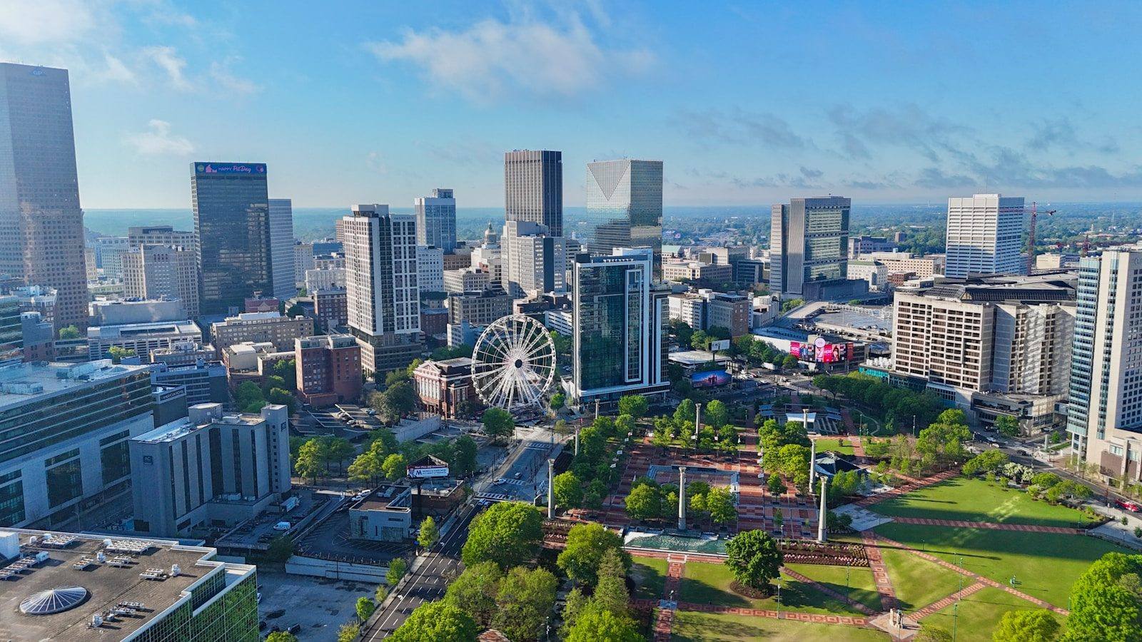 An aerial view of downtown Atlanta with the SkyView Ferris wheel and Centennial Olympic Park below the skyline
